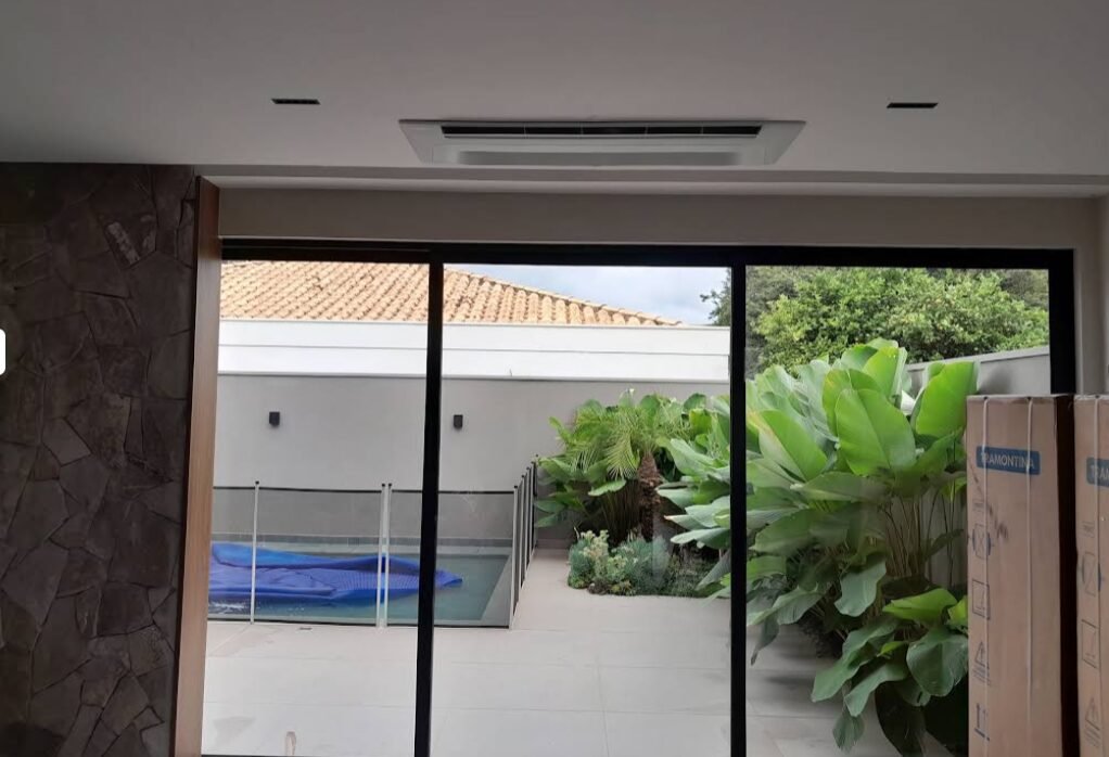 Ar condicionado cassete instalado em sala com vista para piscina
